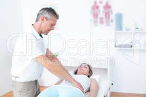 Physiotherapist doing stomach massage to his patient