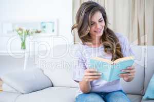 Happy brunette reading a book