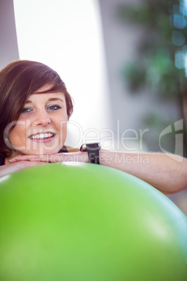 Fit woman leaning on exercise ball