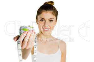 Slim woman holding apple and measuring tape