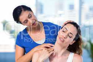 Therapist examining her patients neck
