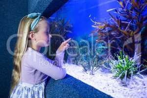Young woman pointing fish in tank