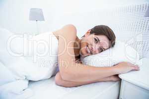 Happy woman in her bed smiling at camera