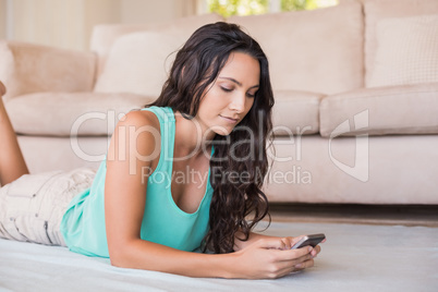 Pretty brunette texting with her smartphone