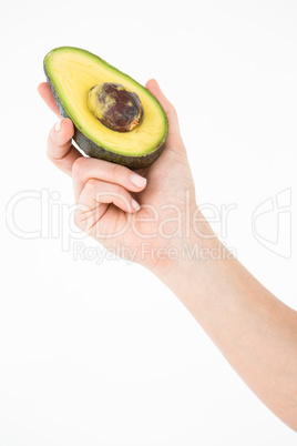 Woman holding half of an avocado