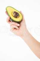 Woman holding half of an avocado
