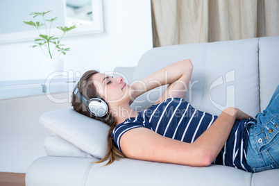 Peaceful brunette listening music on couch