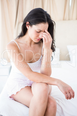 Pretty brunette thinking on bed