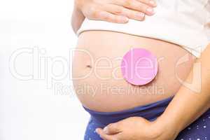 Pregnant woman with sticker on bump