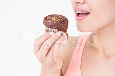 Smiling brunette holding chocolate cupcake