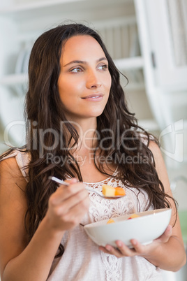 Pretty brunette  eating a fruits salad