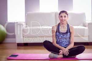 Fit woman sitting on mat