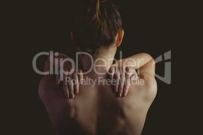 Nude woman with a shoulder injury