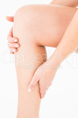 Natural woman touching her painful leg