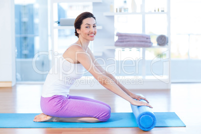 Smiling woman sitting on exercise mat