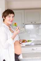 Pregnant woman eating a salad