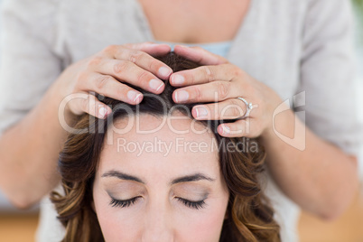 Calm woman receiving reiki treatment