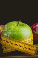 Green and red apples with measuring tape