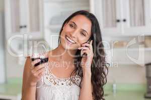 Pretty brunette on the phone having glass of wine