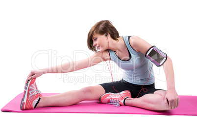 Pretty brunette doing the hamstring stretch on exercise mat