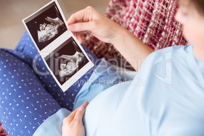 Pregnant woman looking at ultrasound scans