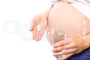 Pregnant woman taking a vitamin tablet