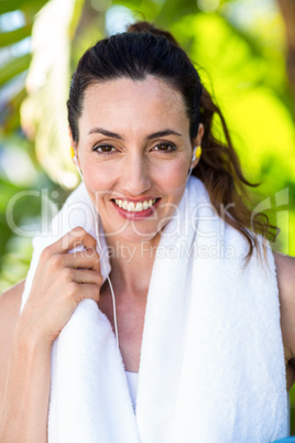 Fit beautiful brunette looking at camera while listening music