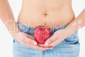 Fit woman standing with red apple