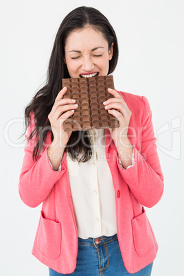 Brunette biting bar of chocolate