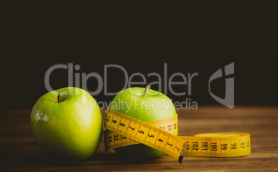 Green apples with measuring tape