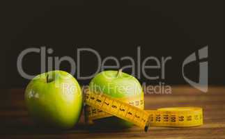 Green apples with measuring tape