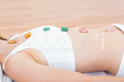 Relaxed brunette lying on mat with stones