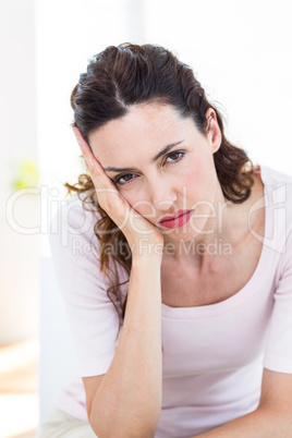 Upset brunette sitting on the couch