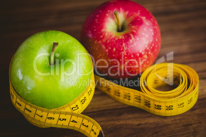 Green and red apples with measuring tape