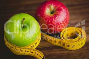 Green and red apples with measuring tape