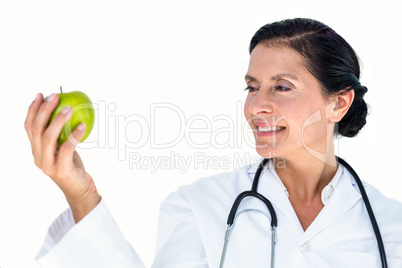 Confident female doctor holding green apple