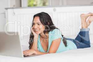 Happy brunette using her laptop