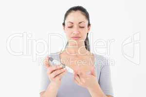 Diabetic brunette using blood glucose monitor