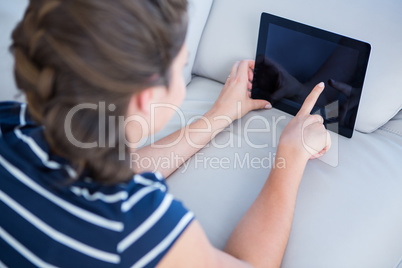 Attractive woman using her tablet lying on couch