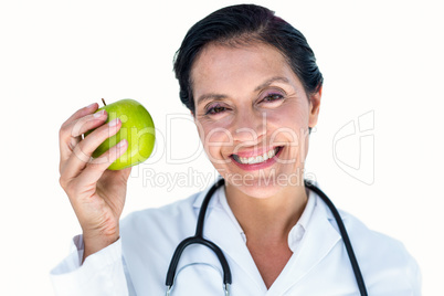 Confident female doctor holding green apple