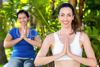 Relaxed woman and her trainer doing yoga