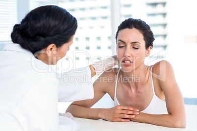 Doctor examining her patients neck