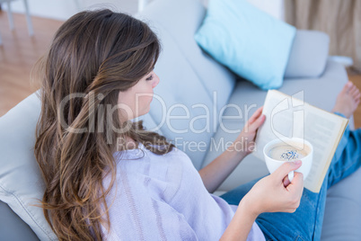 Woman reading book with cup of coffee