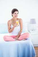 Thoughtful  woman drinking glass of orange juice