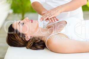 Calm woman receiving reiki treatment