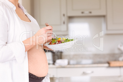 Pregnant woman eating a salad