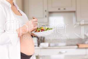 Pregnant woman eating a salad