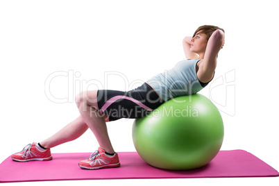 Pretty brunette exercising on fitness ball