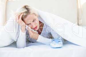 Sad blonde woman lying on the bed