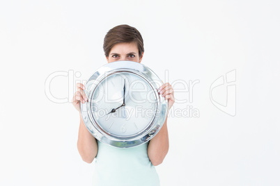 Pretty brunette holding clock